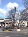 Spiegelsäule in der <a class="mw-selflink selflink">Dr.-Konrad-Adenauer-Anlage</a> - im Hintergrund der Pavillon in der Grünanlage, 2015