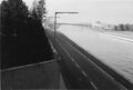 Blick von der Eisenbahnbrücke Richtung  am <a class="mw-selflink selflink">Main-Donau-Kanal</a>. Vorne links Betonmauer mit Stacheldraht Grundstückseingrenzung der ehem.  heute . Hinten rechts über den Kanal die Wohnanlage . Aufnahme vom Oktober 1973.