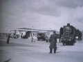 Ein Güterzug quert die <!--LINK'" 0:29--> mit zwei Streckenposten (1950er Jahre)